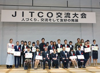 JITCO交流大会の壇上で表彰された入賞者のみなさんと審査員の方々